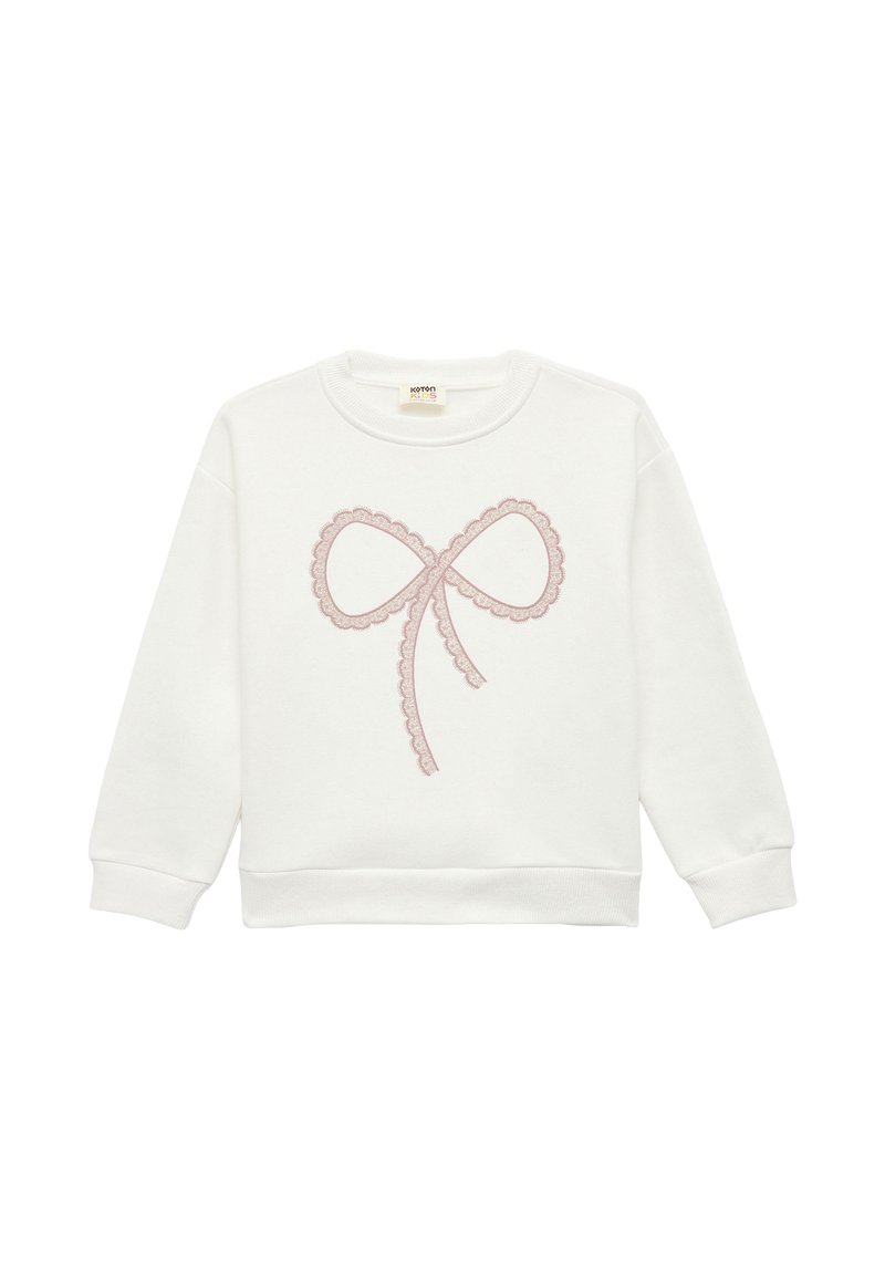 Sweat-shirt blanc avec un design de nœud brodé rose, bords festonnés, col rond et manches longues. Tissu doux et texturé.