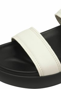 White leather slide sandal with two wide straps, textured surface, and a black rubber sole. Features stitched detailing on the straps.