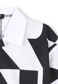 Zwart-wit geometrisch patroon shirt met een spitse kraag en gestructureerde stof. Bevat gedurfde hoekige vormen en contrasterende kleuren.