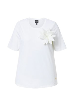 Hvid T-shirt med korte ærmer, rund halsudskæring og et tekstureret hvidt blomstermotiv på venstre side. Fremstillet af en bomuldsblanding.