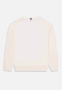 Kremfarget sweatshirt med rund hals, lange raglanermer, ribbestrikkede mansjetter og nederkant. Har en liten stripeaksent ved halsen. Myk tekstur.