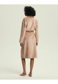 Long, light brown fleece robe with a belted waist, long sleeves, and a collar. The fabric has a soft, smooth texture.