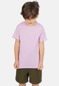 Lila kortärmad T-shirt med rund halsringning, gjord av mjuk bomull, bärs av ett barn med olivgröna shorts. Enkelt design i en solid färg.