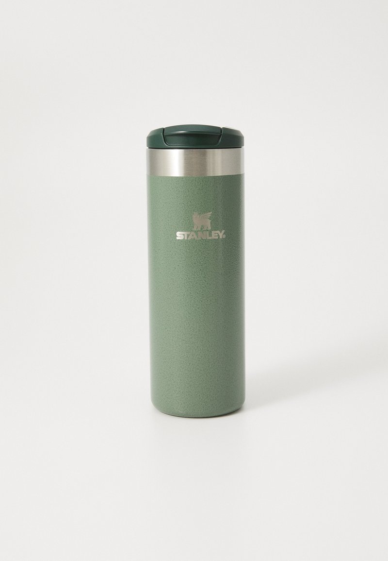 Copo de viagem isolado em verde mate, com colar de aço inoxidável e tampa verde escura. Apresenta uma superfície texturizada e um logótipo gravado.