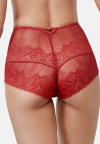 Culotte taille haute en dentelle rouge avec des motifs floraux complexes, bordée de bords festonnés et ornée d'un petit accent doré à l'arrière.