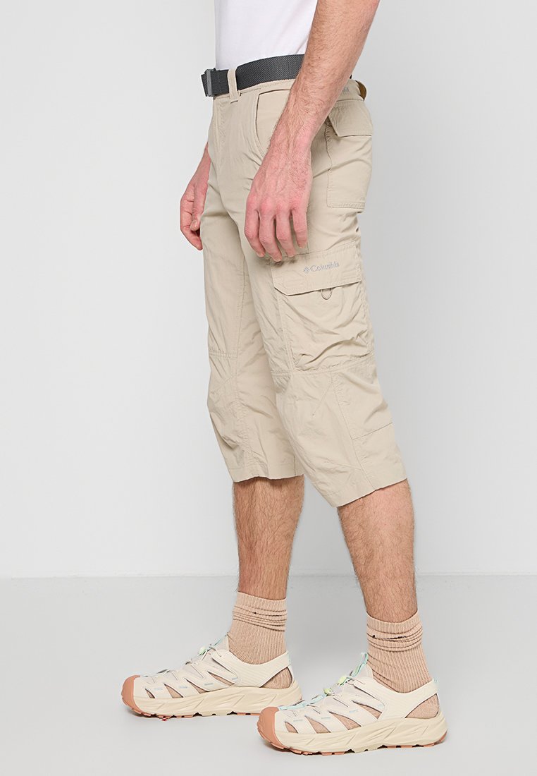 Beige Cargo-Shorts mit knielangem Design, aus leichtem Stoff mit einer strukturierten Oberfläche, seitlichen Taschen und gestickten Details.