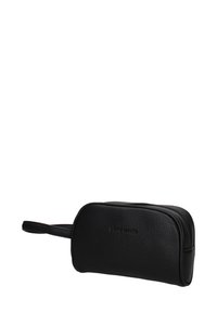 Borsa da toilette in pelle nera con superficie texturizzata, chiusura a zip e manico da polso su sfondo bianco.
