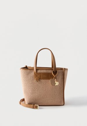 Μπεζ υφαντό γυναικείο τσαντάκι με καφέ δερμάτινες λαβές, αποσπώμενο λουράκι και δύο στρογγυλά κρεμαστά διακοσμητικά σε απλό λευκό φόντο.