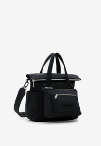 Black nylon tote bag with dual top handles, detachable shoulder strap, zippered pockets, and embossed logo detail on the front.