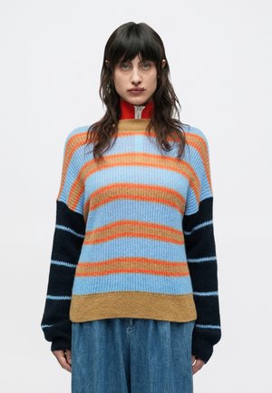 Maglione a righe con un mix di tonalità blu, arancione e marrone, maniche oversize e una texture a coste. Dettaglio del colletto con cerniera.