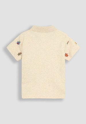 Kreemivärviline lühikeste varrukatega polo särk, millel on krae. Varrukatel on värvikad tikitud putukate mustrid.