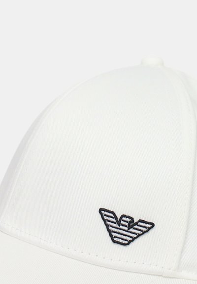 Cappello da baseball bianco con forma strutturata, dotato di un logo ricamato in bianco e nero sul davanti e texture a coste.