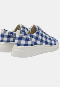 Sneakers in tela a scacchi blu e bianchi con una robusta suola in gomma bianca e lacci beige, caratterizzati da una texture liscia e un design pulito.