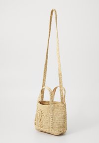 Pletená slaměná taška v přírodní barvě s dvěma krátkými uchy, dlouhým popruhem a vyšívaným květinovým detailem na jednom boku.