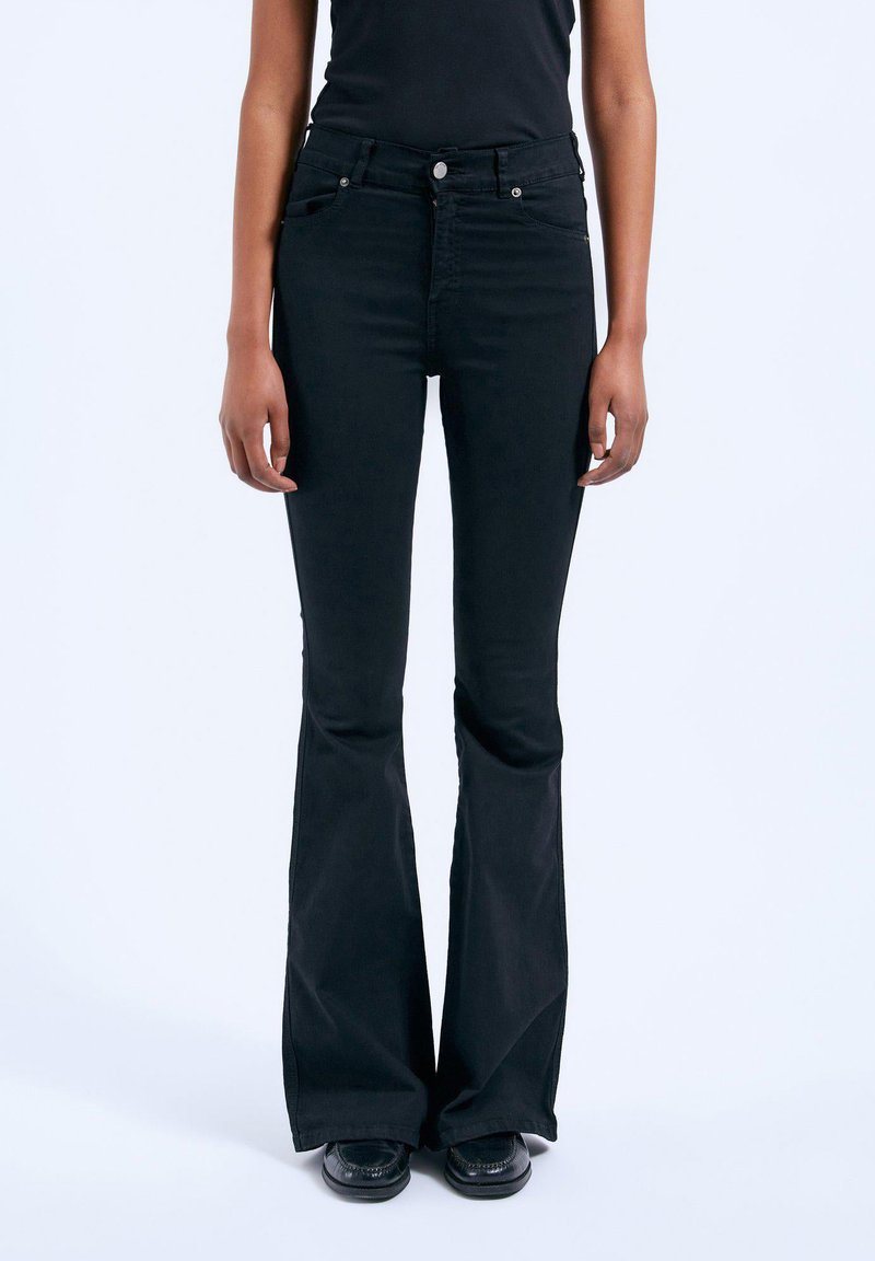 Black flared jeans with a high waistband, front and back pockets, and a smooth fabric texture. Features a front button and zipper closure.