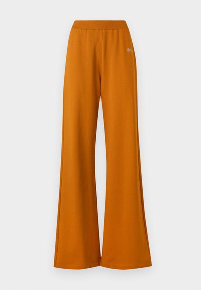 Pantalones anchos naranja con cinturilla elástica, confeccionados en una tela suave. Presenta un sutil bordado del logo en la parte frontal.
