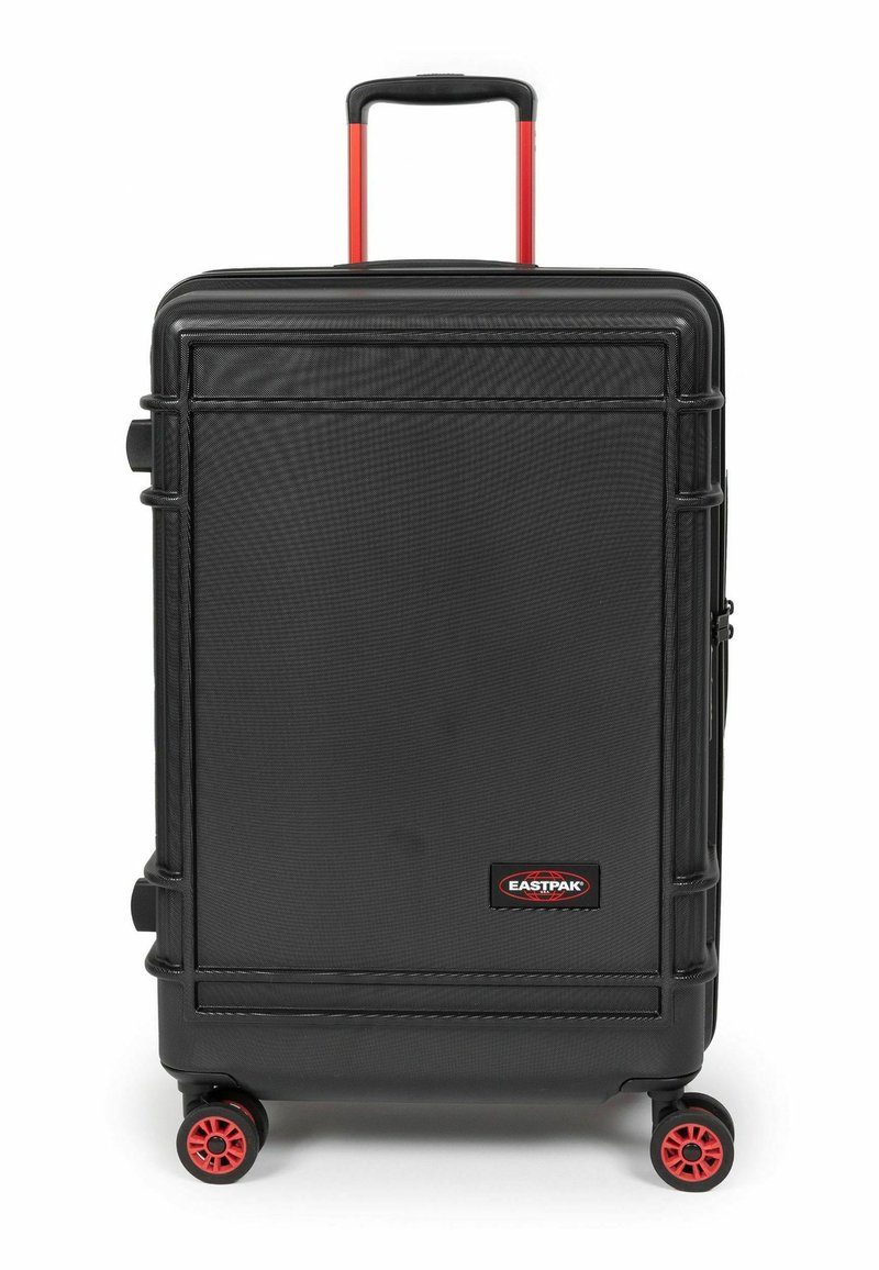 Černý tvrdý kufr s texturovaným povrchem, červenými koly a výsuvnou černou rukojetí. Na přední straně je značka Eastpak.