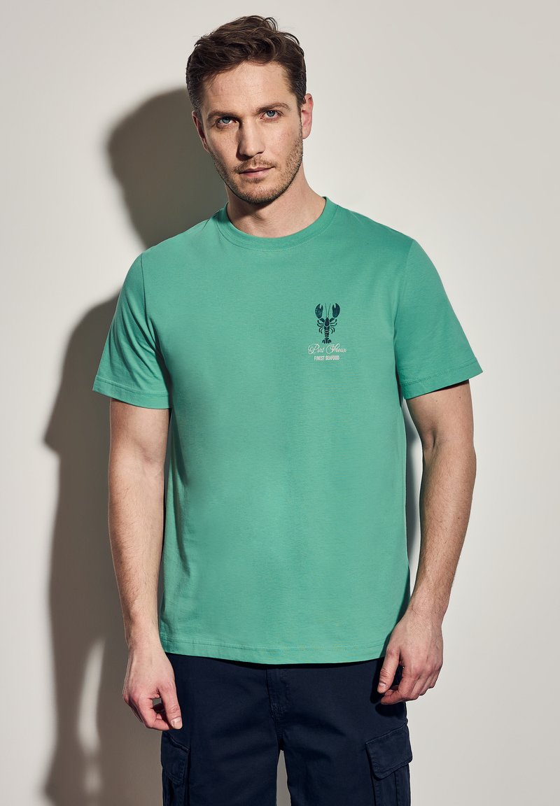 Tyrkysové bavlněné tričko s kulatým výstřihem, krátkými rukávy a potiskem humra s textem na levém prsu. Hladká textura.