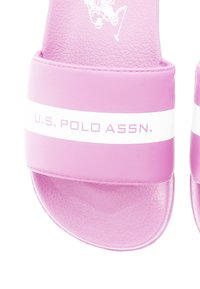 Rosa gummiskor med texturerad yta, med en vit rand och texten "U.S. POLO ASSN." på den övre remmen. Rundad öppning för tårna.
