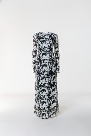 Langærmet maksikjole i sort og hvid med blomstermønster. Har en tætsiddende overdel og et flydende skørt. Fremstillet af letvægtsstof.