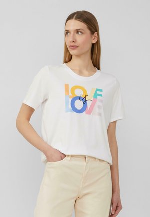 T-shirt en coton blanc avec le texte "L'AMOUR est L'AMOUR" en lettres colorées. Manches courtes et col rond. Coupe décontractée.