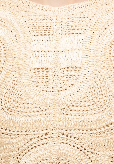 Tissu beige en crochet avec un motif carré comportant des boucles concentriques et des textures de points variées.