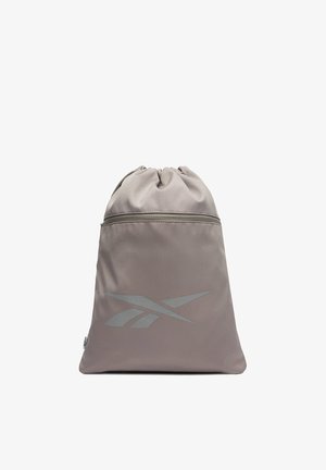 Mochila gris con cordón, con un bolsillo delantero con cremallera y el logo reflectante de Reebok centrado en la parte frontal.