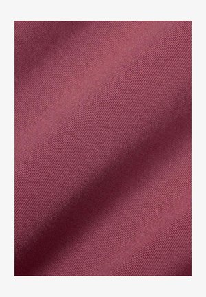 Nahaufnahme von gefaltetem, strukturiertem Stoff in gedämpftem Mauve mit feinem diagonalem Webmuster und weichen Schatten.