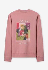 Sweatshirt mauve avec un graphique abstrait de musiciens de jazz colorés, texte « Solo Jazz » en haut et « laissez la musique prendre le contrôle » en dessous.