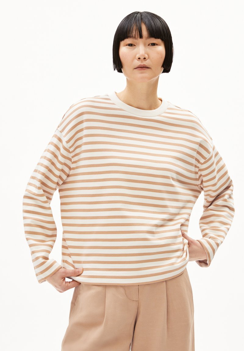 Leichtes, langärmeliges gestreiftes Oberteil in Beige und Weiß, mit Rundhalsausschnitt und lockerer Passform, kombiniert mit beigen Hosen.