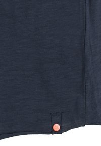 Navy blue t-shirt with a soft, textured fabric; features a rounded hem and a small orange button with "SL" on the left side.