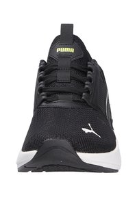 Schwarze Sportschuhe mit einem Obermaterial aus Mesh, flachen Schnürsenkeln und einem weißen Logo. Sie verfügen über eine abgerundete Sohle und ein strukturiertes Design für besseren Halt.