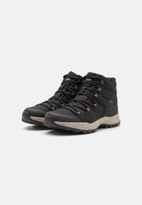 Scarpe da trekking nere con design a collo alto; parte superiore in tessuto testurizzato, suola beige a contrasto e lacci arancioni con occhielli rinforzati per la durabilità.