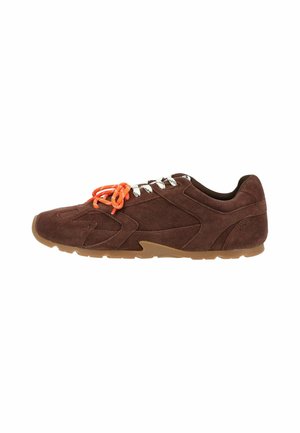 Sneakers casual in pelle scamosciata marrone con suola in gomma e lacci bianchi, con un set di lacci arancioni brillanti legati sopra.