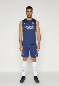 Jersey sin mangas de color azul oscuro y pantalones cortos con el logotipo de "Qatar Airways". Medias blancas hasta la rodilla y zapatillas deportivas negras. Marca Nike en las prendas.