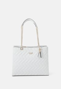 Bílá prošívaná taška přes rameno s rukojetí z stříbrného řetízku, s vyraženým logem na přední straně a přívěskem jako detailem. Má pevný tvar a hladký povrch.