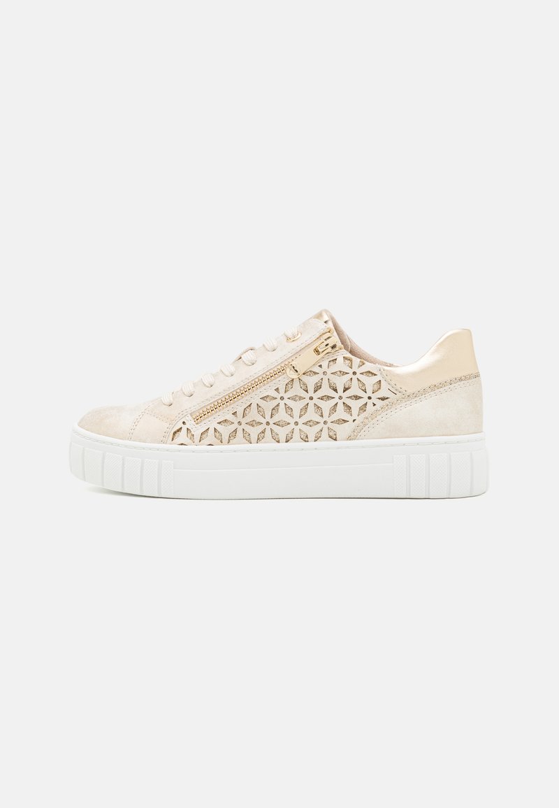 Sneaker in suede beige con design geometrico tagliato al laser sui lati, dettagli in hardware dorato, suola bianca e lacci piatti. Forma semplice e moderna.