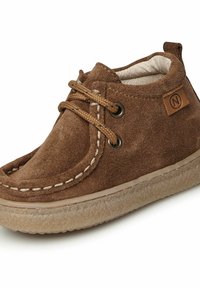 Stivali chukka in suede marrone con occhielli in metallo, lacci tondi beige e suola in gomma testurizzata. Presenta dettagli di cucitura e un'etichetta con il logo.