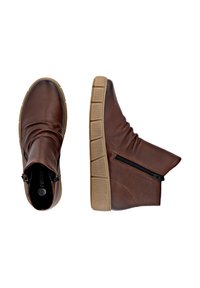 Botas de cuero marrón hasta el tobillo con una superficie texturizada, cremallera lateral y una suela de goma beige gruesa. Presenta un diseño holgado para mayor comodidad.