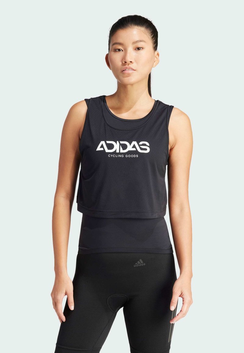 Top de ciclismo negro sin mangas con diseño crop, que presenta un logo blanco de "ADIDAS CYCLING GOODS". Textura suave, combinado con leggings ajustados negros.