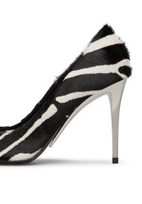 Scarpa con tacco alto a strisce zebrate in bianco e nero, realizzata in pelliccia testurizzata, con tacco metallico argento e punta appuntita.