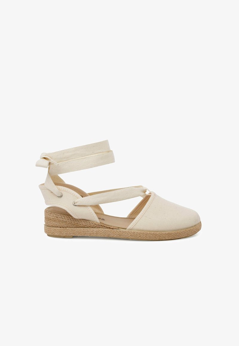 Espadrille in tela beige con cinturino alla caviglia, caratterizzata da una suola in juta intrecciata. Il design include punta chiusa e tallone aperto.