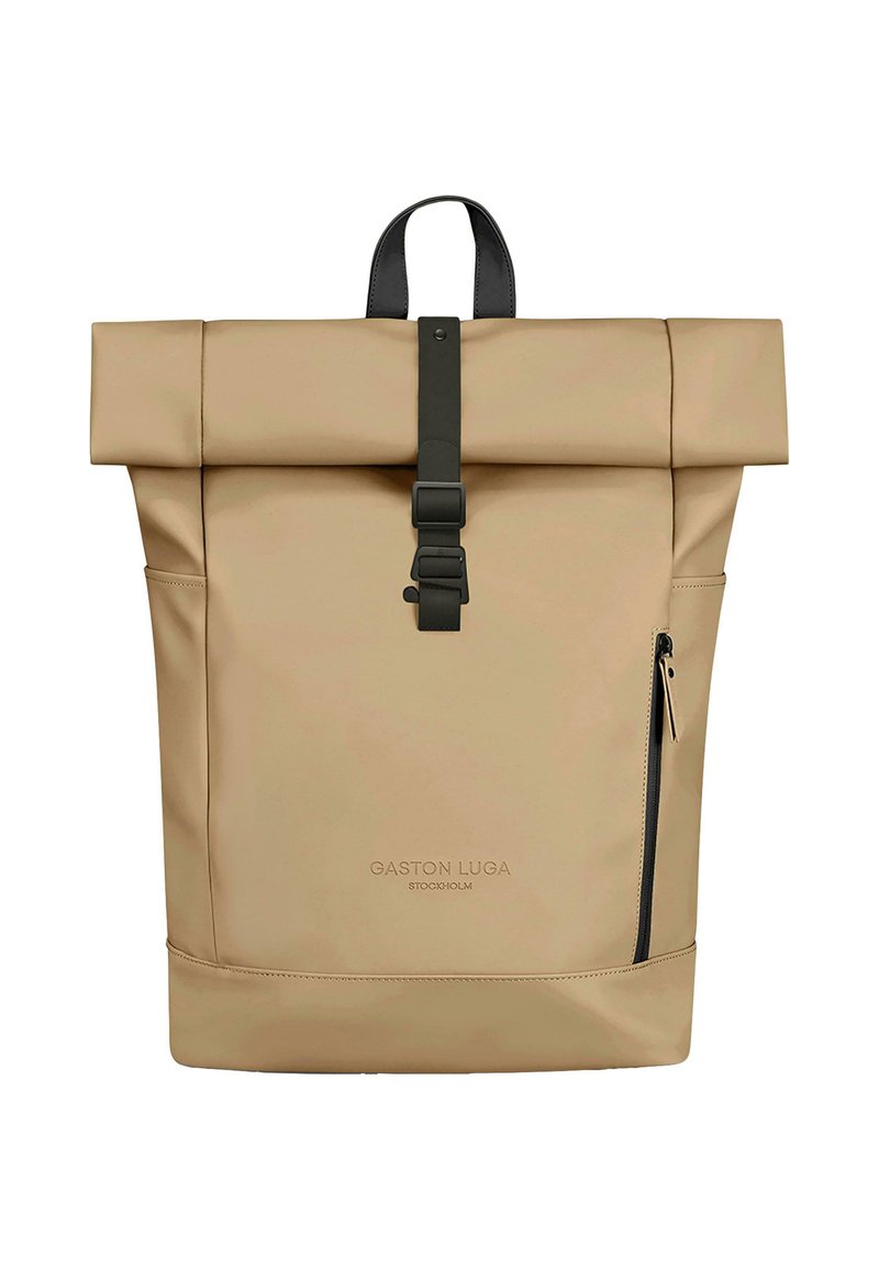 Beige rulle-top rygsæk lavet af vandtæt materiale med sort spænde rem, sidelomme med lynlås og prægede logo foran.