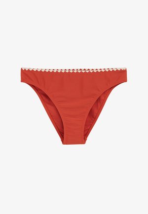 Crvena bikini donica od glatkog materijala, s bijelim elastičnim pojasom s valovitim rubovima. Klasičan stil s minimalnom pokrivenošću.