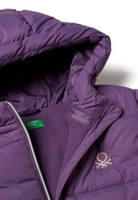 Giacca a vento viola con cappuccio, caratterizzata da un design trapuntato, fodera interna morbida e chiusura frontale con zip. Etichetta verde con il marchio all'interno.