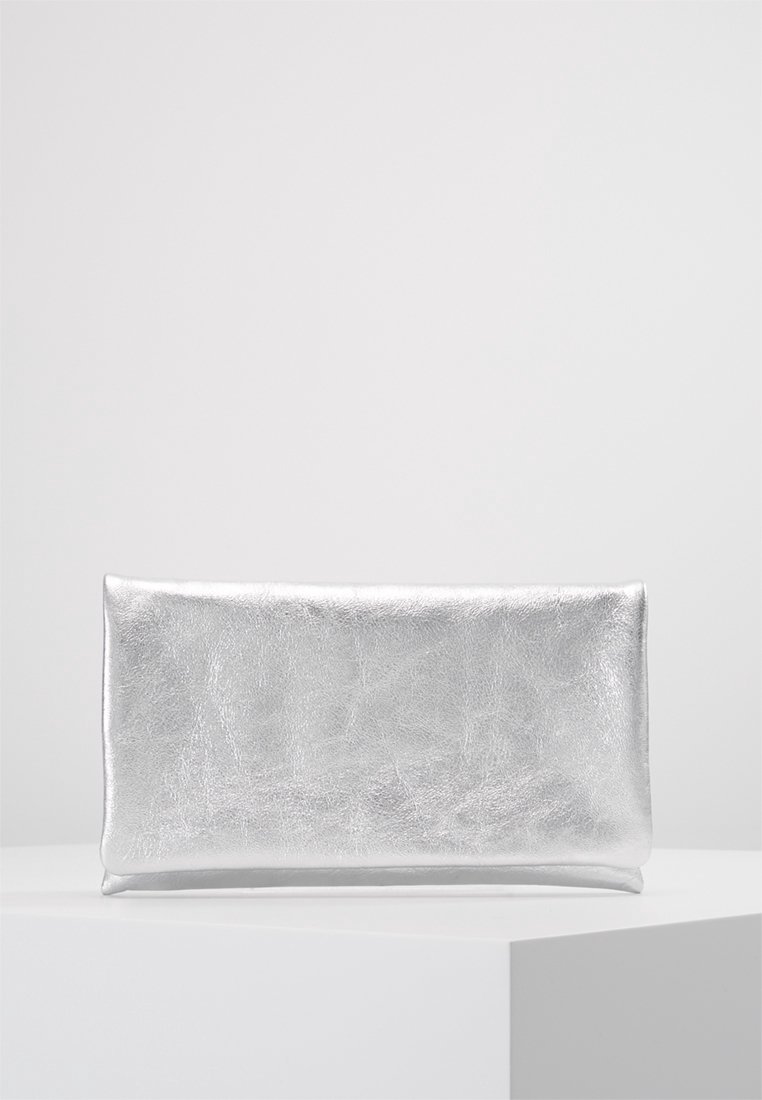 Pochette rectangulaire argentée brillante avec une texture métallique lisse, placée sur un socle carré blanc sur fond gris clair uni.