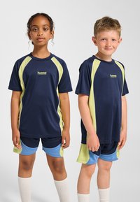 Marinblå sportskjortor med limegröna detaljer, kortärmade och med rund hals, kombinerade med matchande shorts och knähöga strumpor.