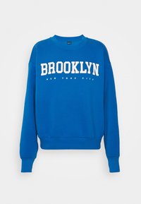Felpa blu in misto cotone con la scritta "BROOKLYN NEW YORK CITY" in bianco, colletto rotondo, maniche lunghe e bordo e polsini a coste.