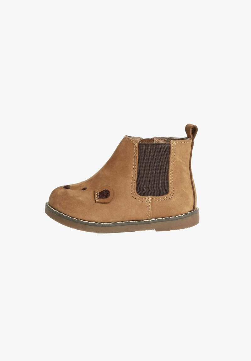 Bottines en daim beige avec des panneaux élastiques sur les côtés, un bout arrondi, des détails cousus et une petite languette à l'arrière pour un enfilage facile.