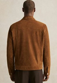 Ruskea nubuk jacket, jossa on sileä pinta ja klassinen kaulus, sekä nappiyksityiskohtia hihoissa. Takakatsaus, istuva malli.
